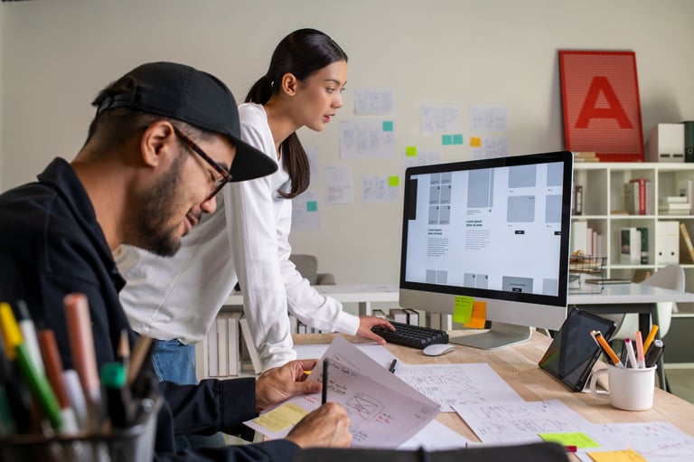 UX UI designers discussing wireframes for website design